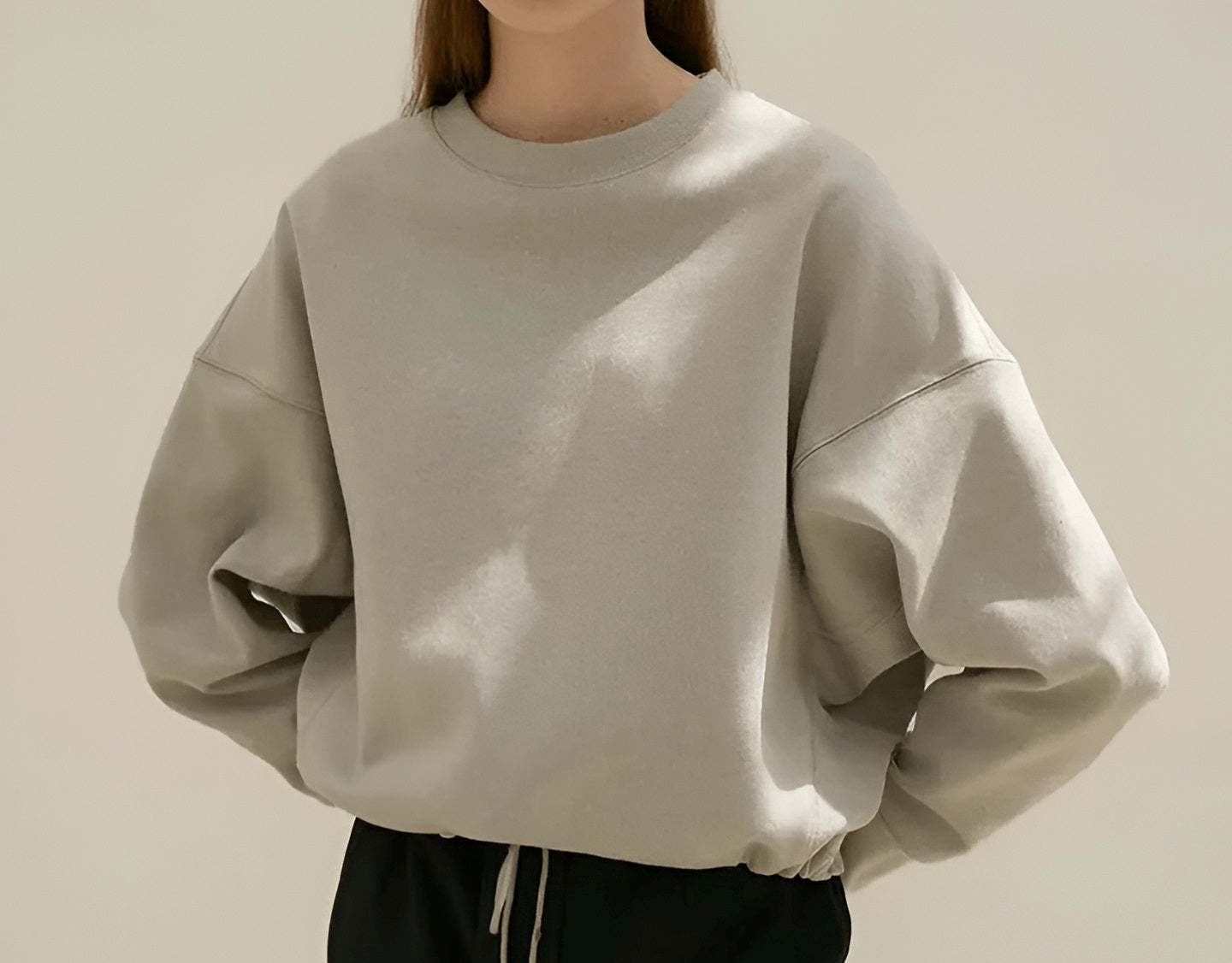 Oversized beige drop-shoulder crewneck sweatshirt on a model.