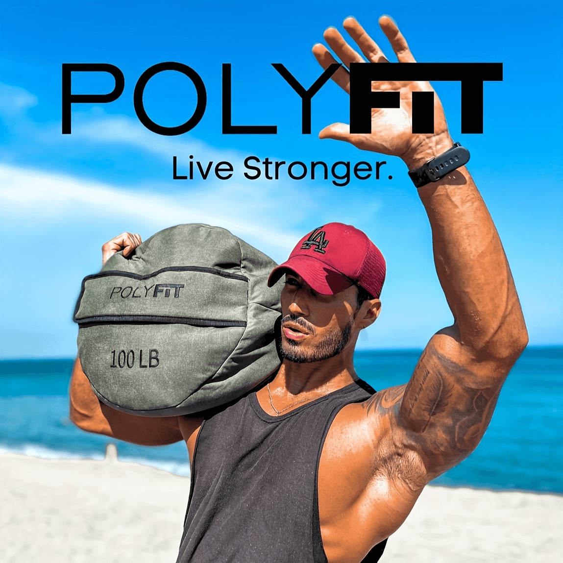 Man lifting PolyFit 100-lb sandbag on beach for strength training