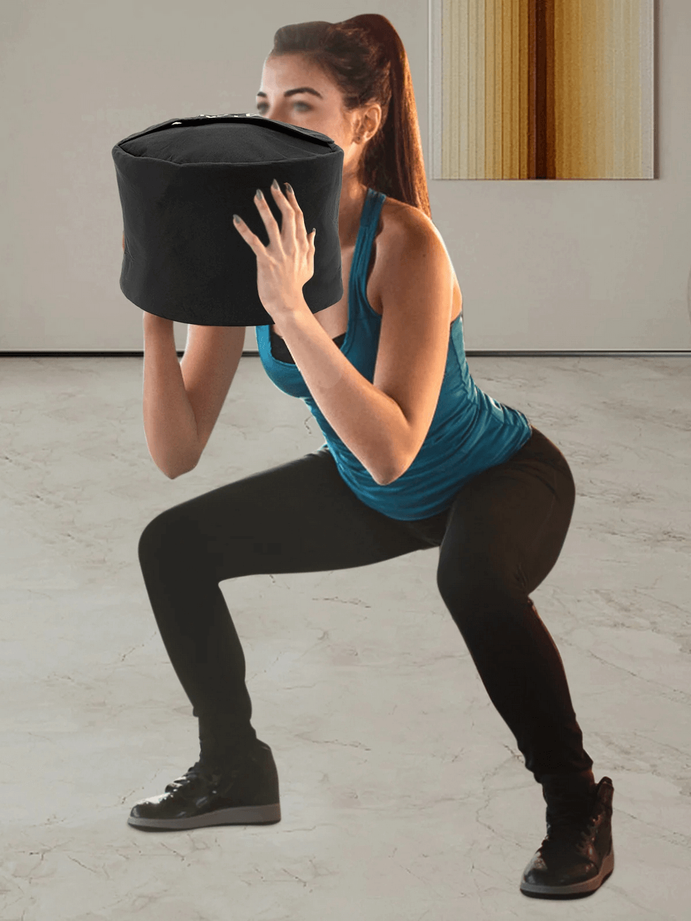 Woman performing squat with 150 LB heavy-duty sandbag for functional fitness and power training.