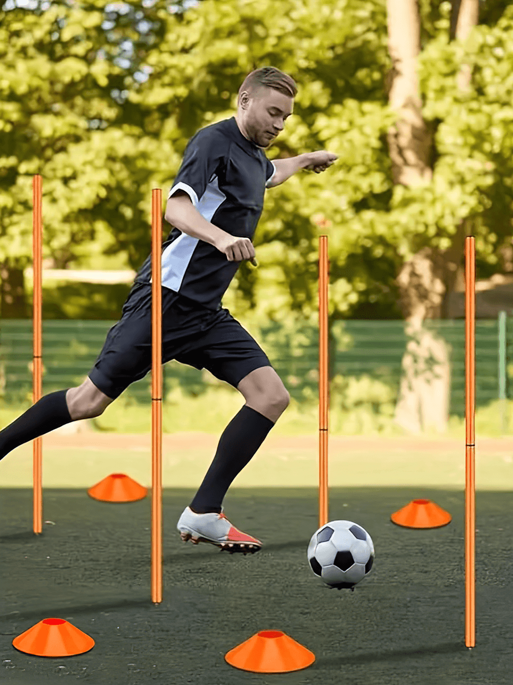 Soccer player navigating agility poles and cones set, enhancing speed and coordination on grass with training equipment.