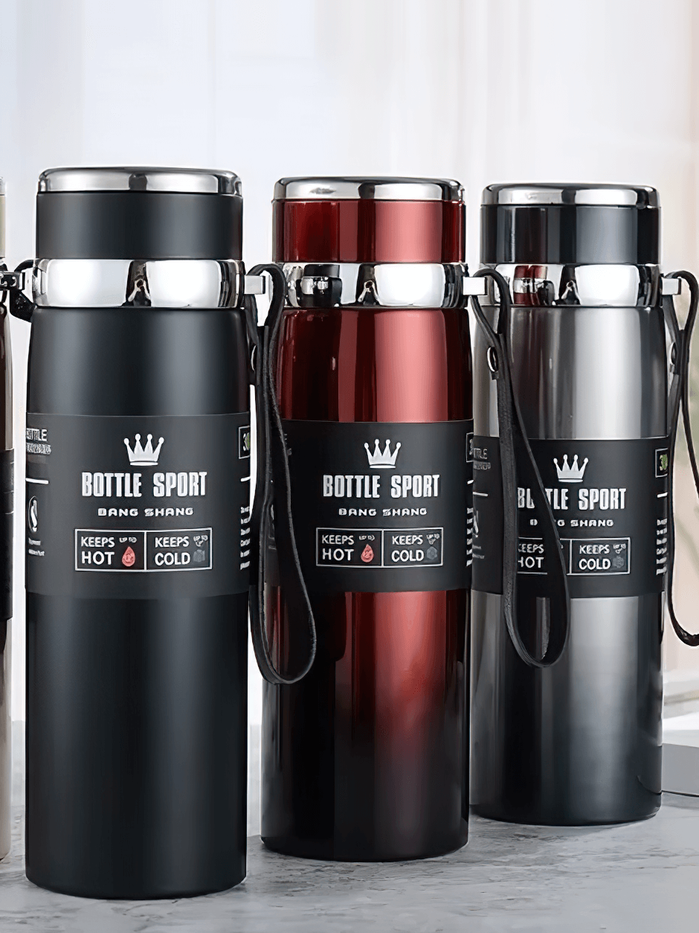 Stainless steel insulated sport thermos bottles in black, red, and silver, featuring leakproof lids and wrist straps for travel and sports.