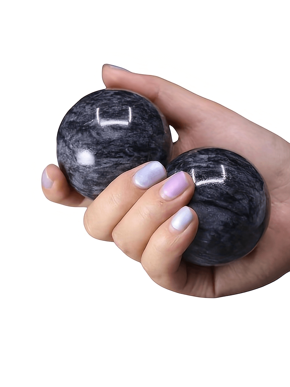 Hand holding natural stone Baoding balls for relaxation and stress relief.