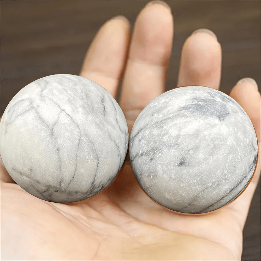 Natural stone Baoding balls for relaxation and hand therapy, held in palm. Ideal for stress relief, meditation, and focus exercises.