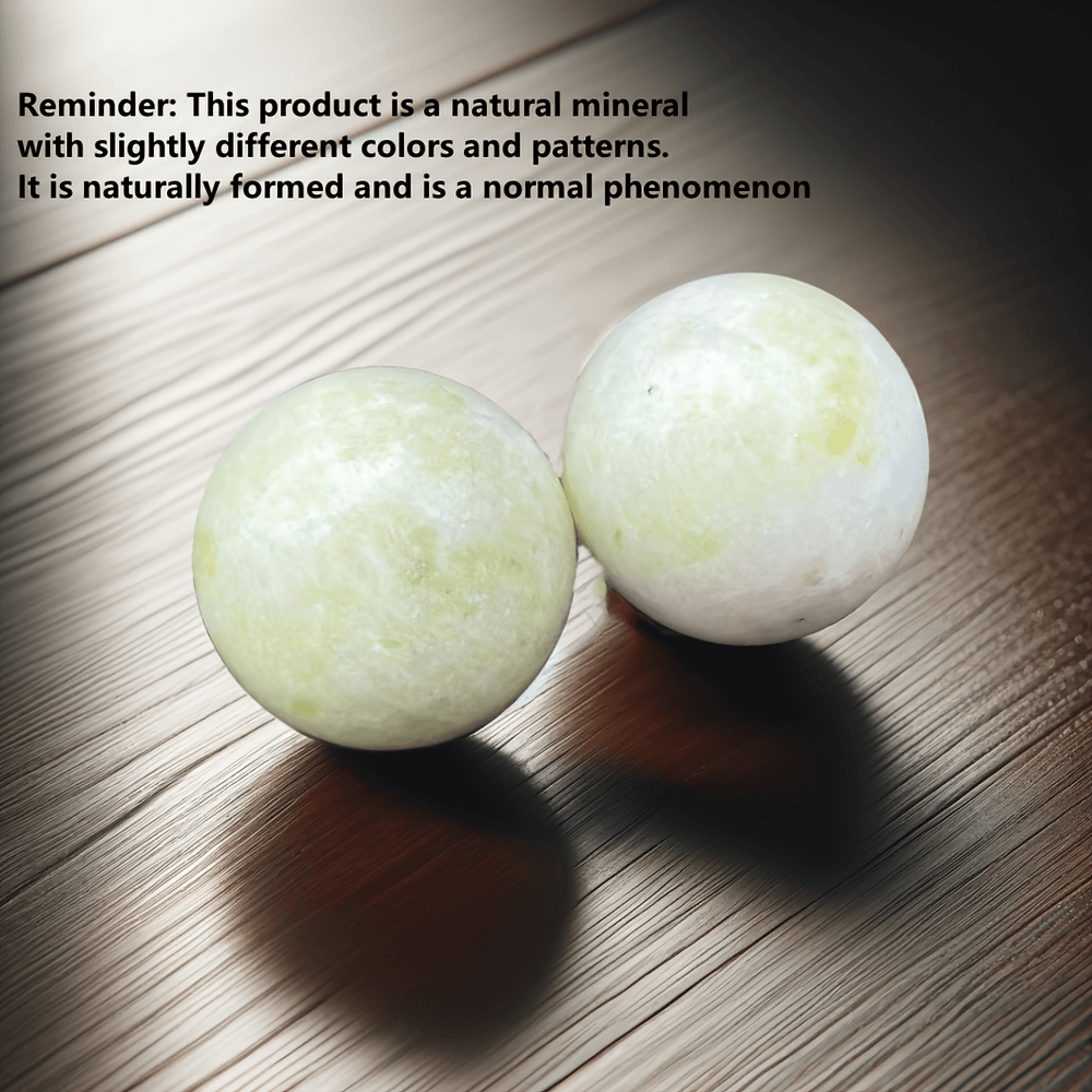 Natural stone Baoding balls for relaxation and hand therapy on wooden surface, unique patterns enhancing focus and tension relief.