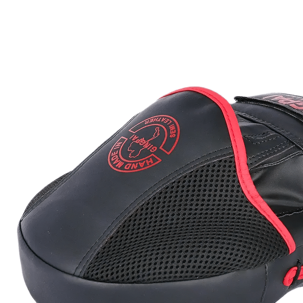 Boxing PU leather target pad with ergonomic design and Velcro closure for training and sparring in black and red.