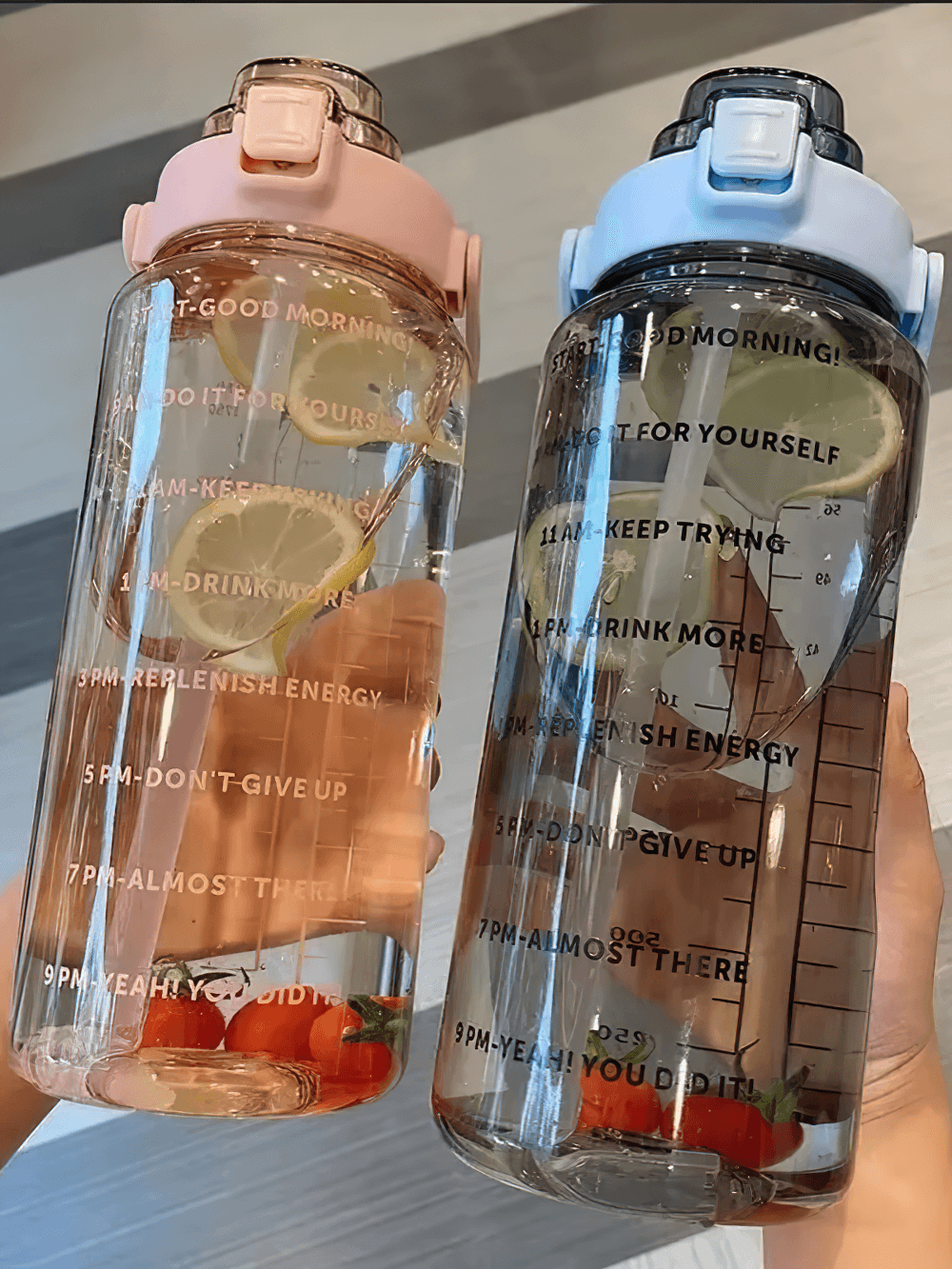 Two stylish 2L sports water bottles with motivational time markers, featuring straws and sturdy handles for easy carrying.