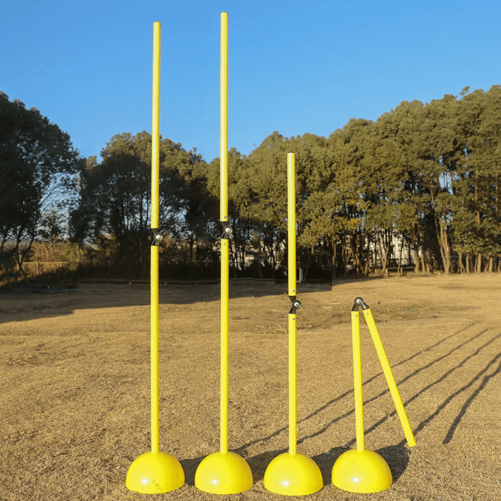 Adjustable agility poles for football training setup on a field for soccer drills and footwork exercises, featuring hinged connectors.