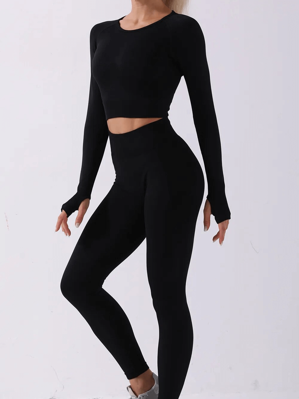 Woman in black seamless yoga set, full-sleeve top and leggings, perfect for sports, windproof and anti-shrink nylon outfit.