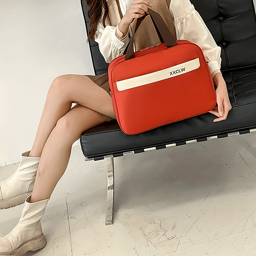 Woman sitting with red duffle bag, showcasing stylish and modern travel accessories.