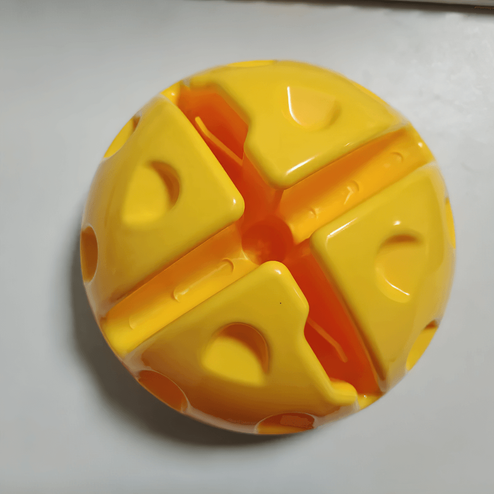 Yellow puzzle ball toy with interlocking pieces on white surface.