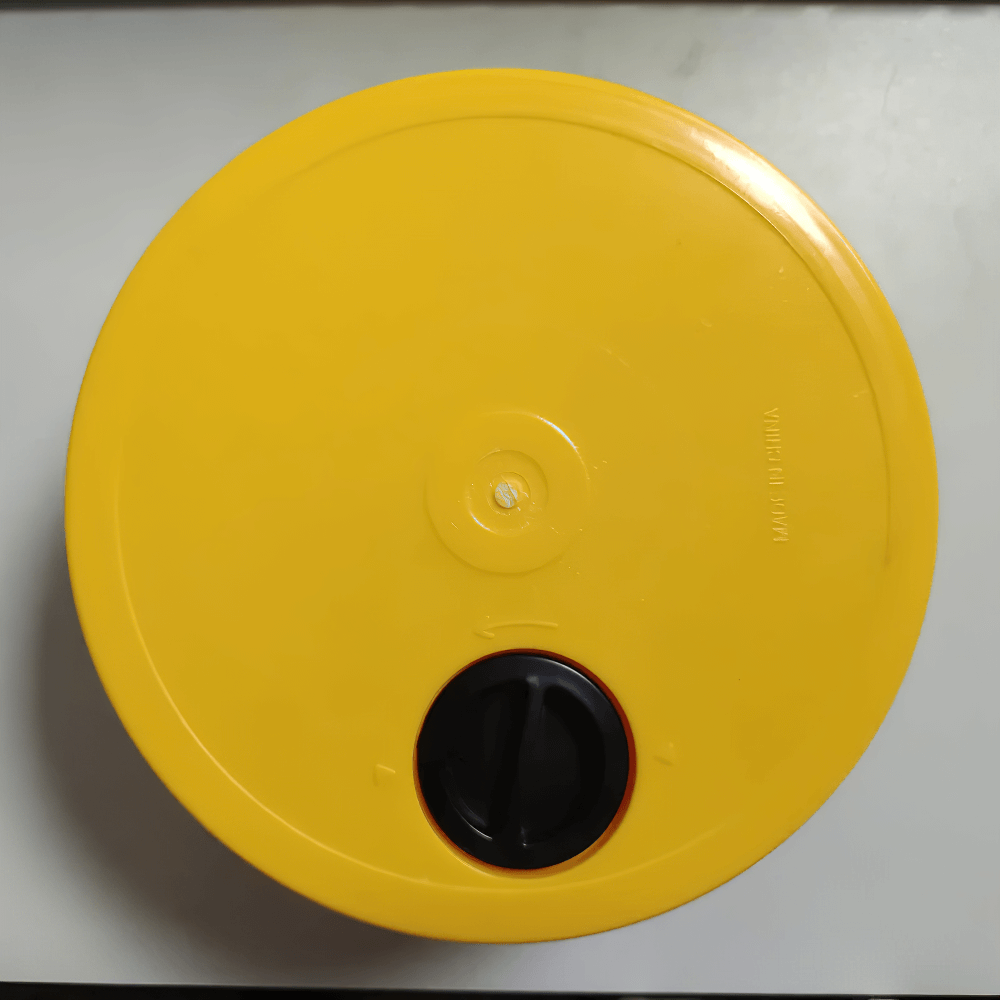 Top view of a yellow plastic lid with a black handle, ideal for containers or storage purposes.