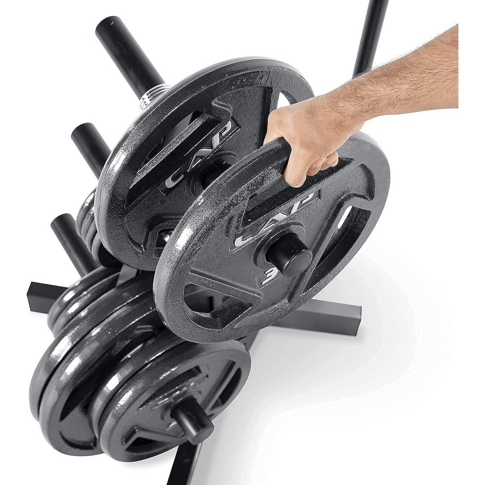 Hand placing 4pcs cast iron weight plates on a rack, ideal for strength training and workouts with Olympic bars. Durable gym equipment.