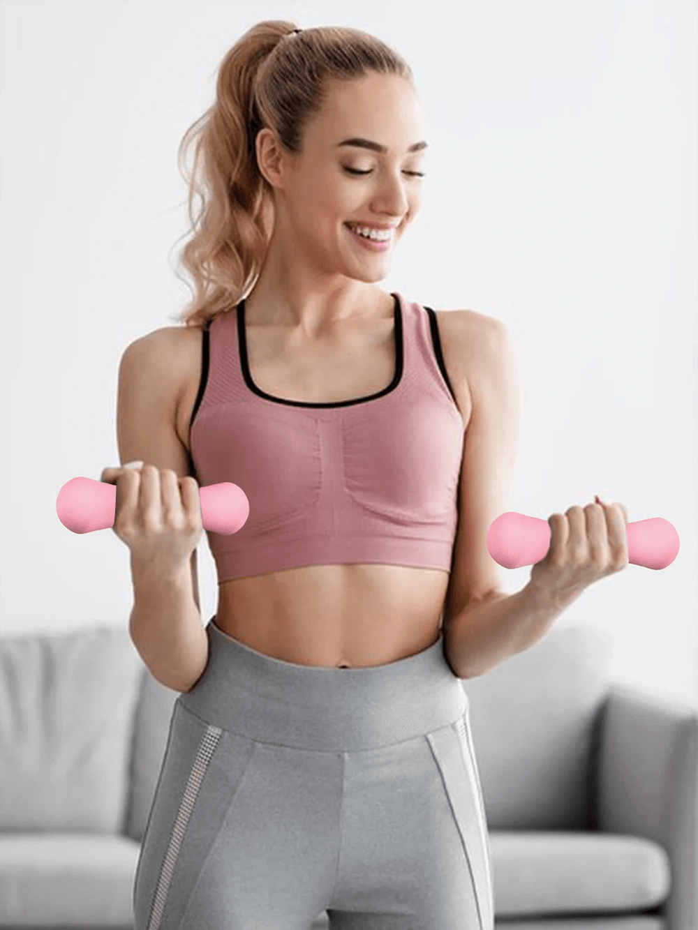 Woman exercising with pink 500g cast iron dumbbells for muscle fitness and rehabilitation workouts at home.