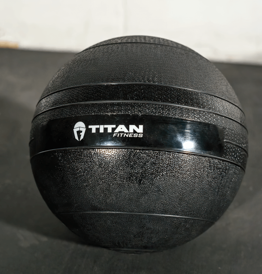 60 LB Titan Fitness Black Weighted Slam Ball with textured shell, ideal for HIIT, cross training, and strength workouts.