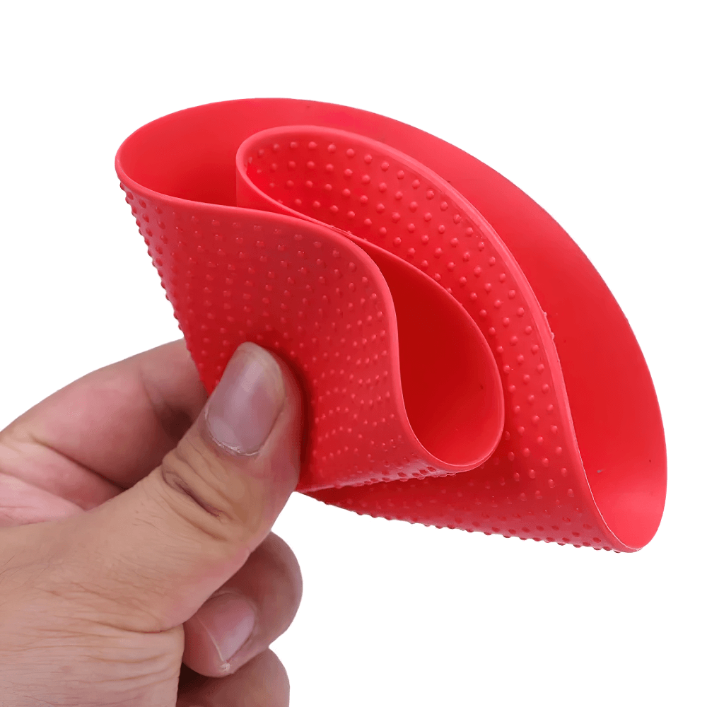 Non-slip red soccer training marker mat held in hand, showcasing flexible and grippy surface for agility drills.