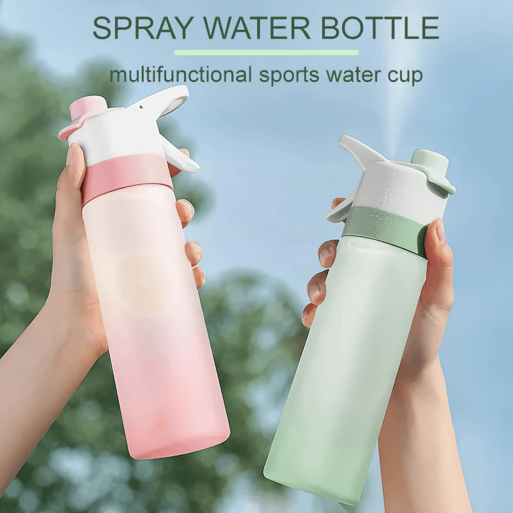 Hands holding a 650ml Spray Water Bottle for Outdoor Activities - SF3492 in pink and green with mist function for gym and travel.