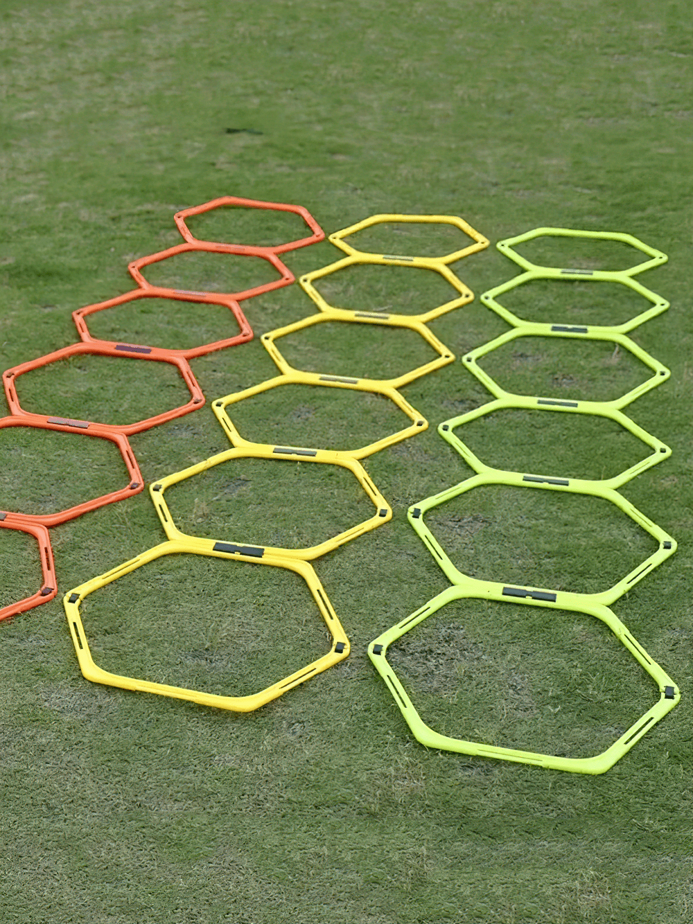 Colorful hexagonal agility hurdles and connectors for speed training on grass