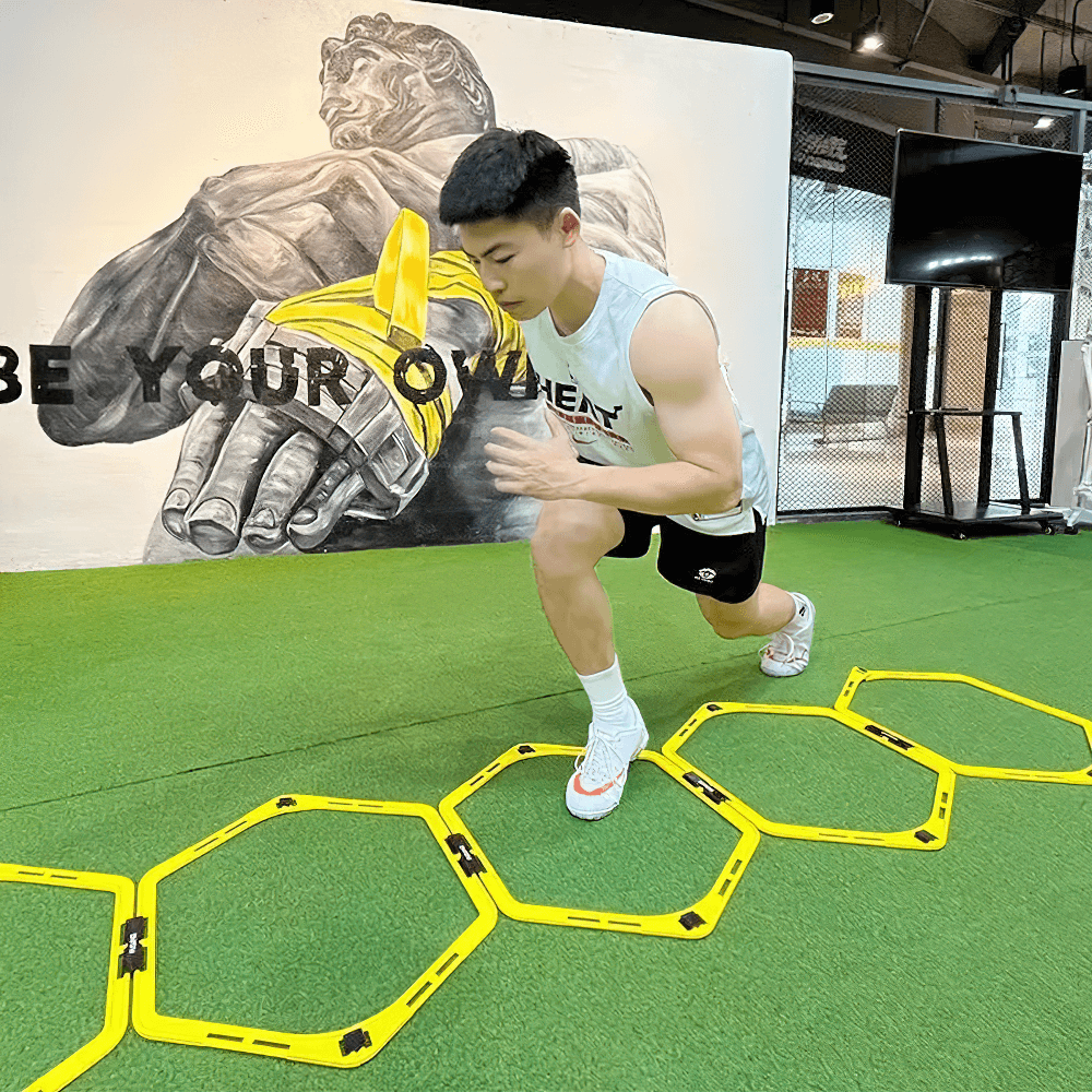 Athlete using modular hexagonal hurdles for agility training in a gym, focusing on speed and coordination.