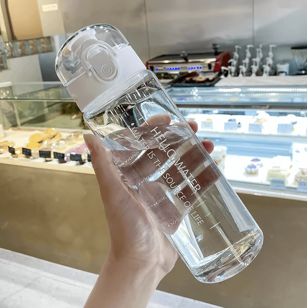 Hand holding 780ml clear water bottle with time markers and locking lid, perfect for daily hydration and eco-friendly living.