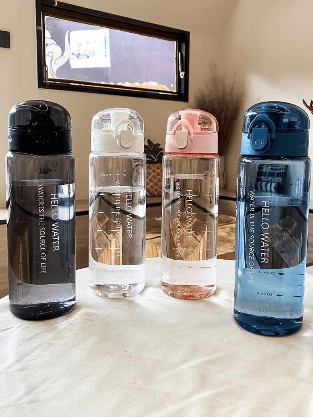 Eco-friendly sporty water bottle set with time markers for hydration in various colors on a white table, perfect for on-the-go use.