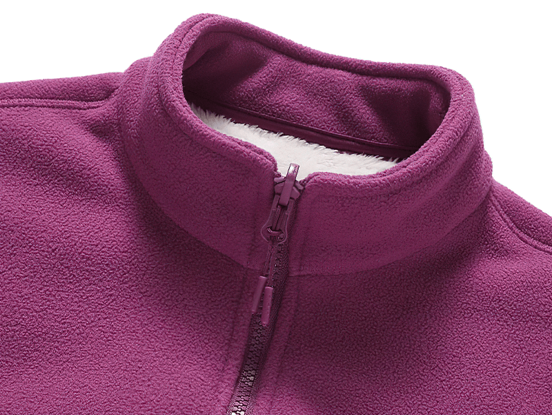 Close-up of a purple zip-up fleece jacket with a stand collar, showcasing soft fabric and cozy warmth, perfect for winter fashion.