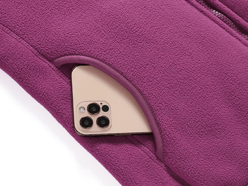Plum-colored fleece jacket with an inner pocket holding a smartphone, showcasing practical design for women's winter wear.