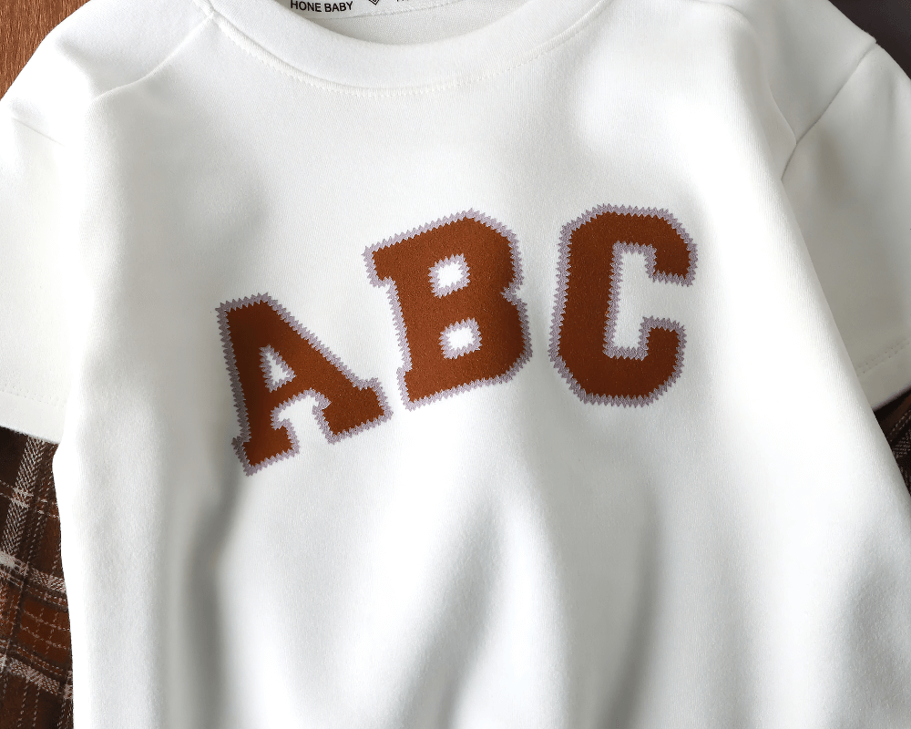 Children's ABC lettered sweatshirt with plaid sleeves, perfect for a stylish and cozy school or playtime look for kids.