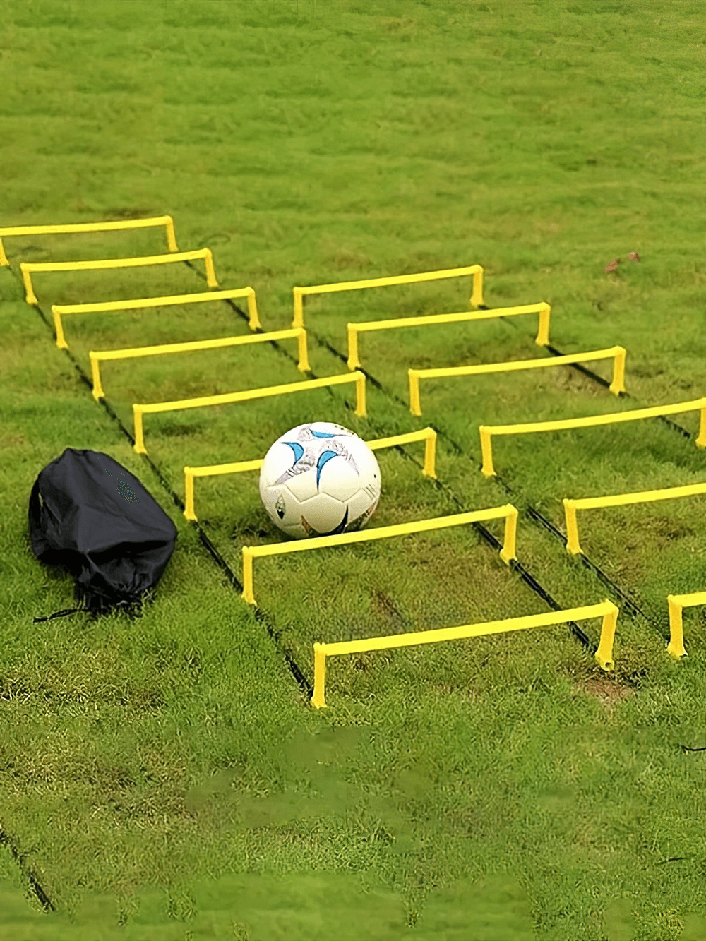 Yellow adjustable agility ladder on grass with soccer ball, perfect for speed and coordination training in sports like football.