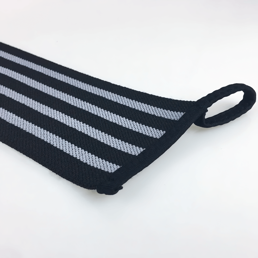 Close-up of adjustable elastic wrist wraps with Velcro for weightlifting, featuring durable fabric and loop for secure fit in gym exercises.