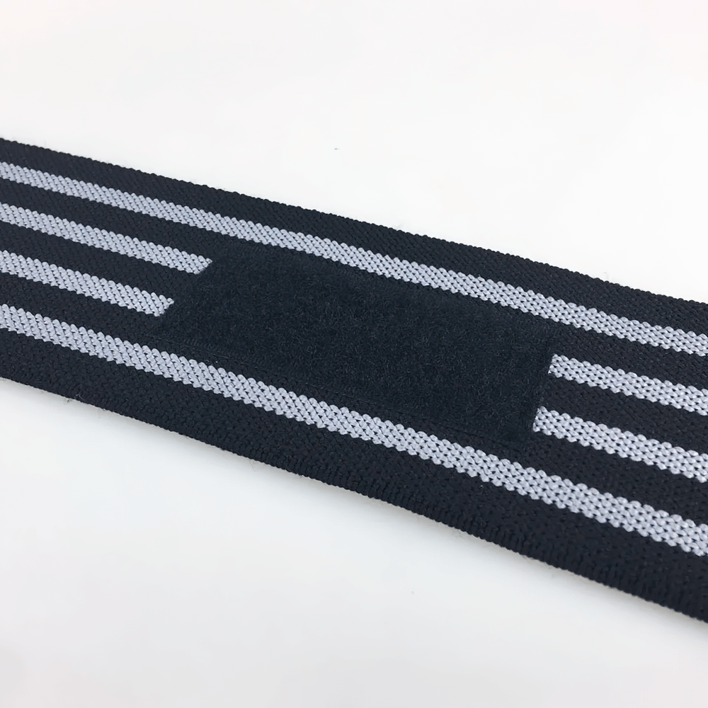 Close-up of black and gray adjustable elastic wrist wraps with Velcro closure for weightlifting and fitness support.