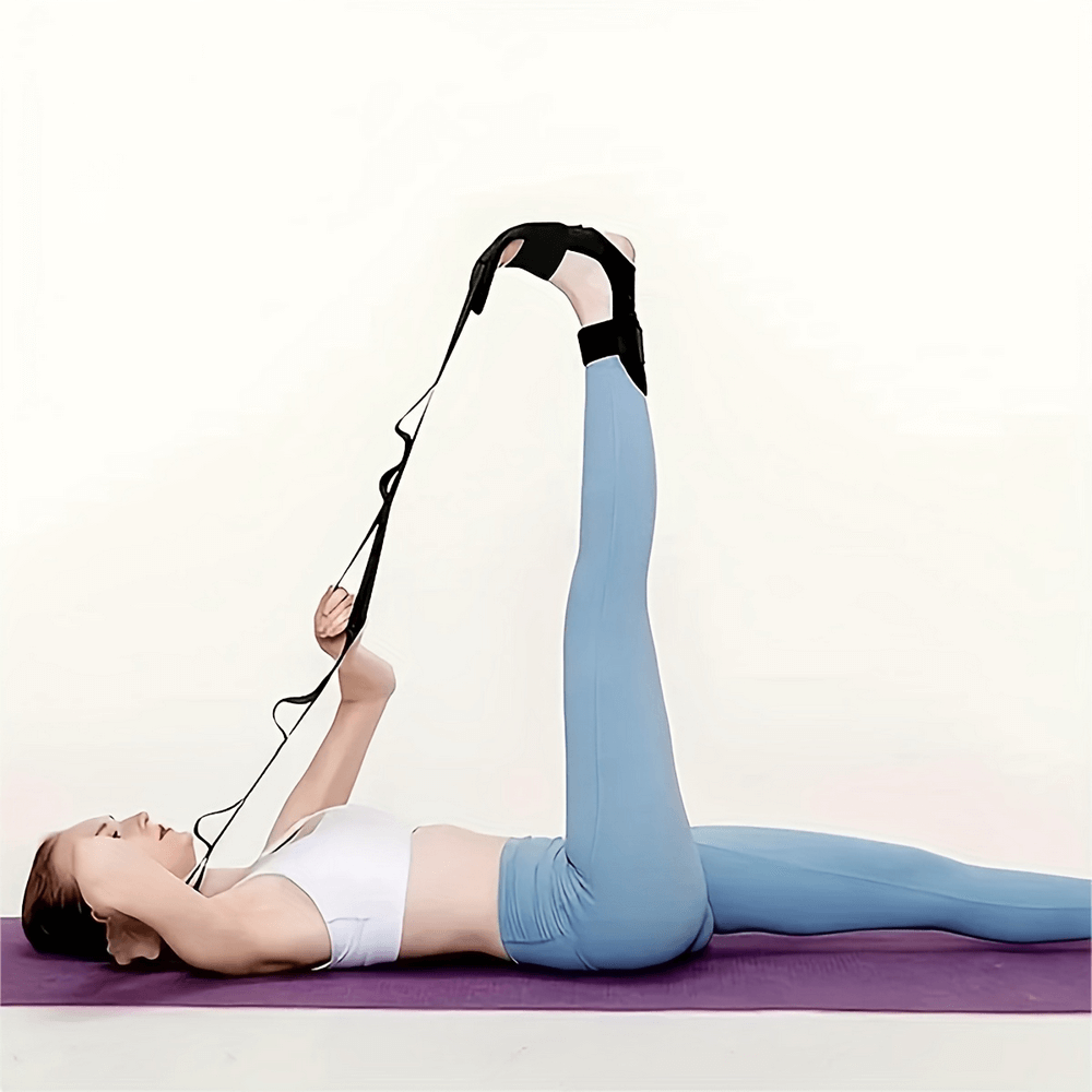 Woman using adjustable foot and calf stretcher for leg flexibility on yoga mat, ideal for therapy and recovery.