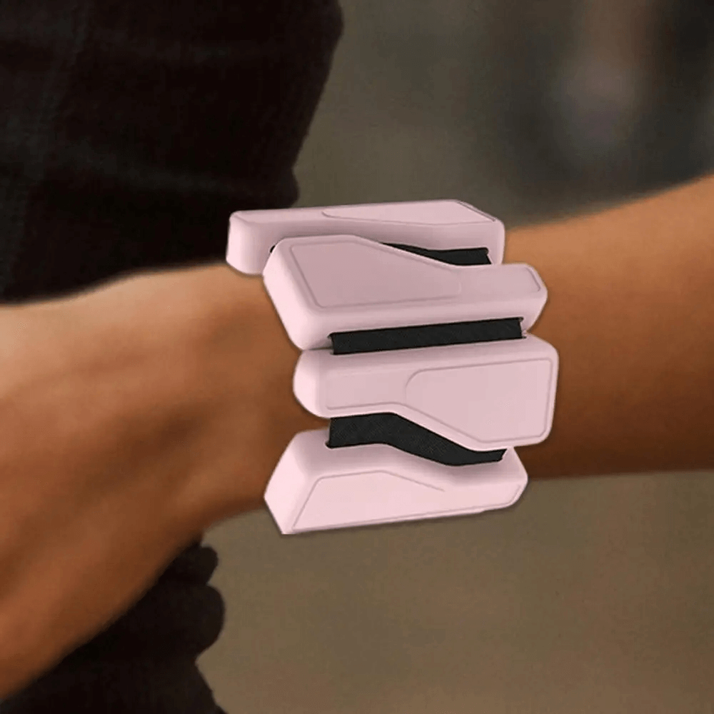 Person wearing adjustable pink silicone wrist weights for fitness, SF3310, on their wrist in a gym setting.