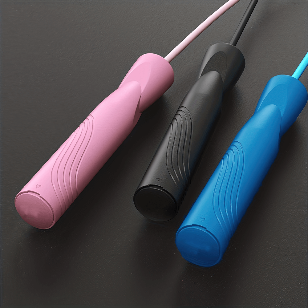 Three ergonomic-handled jump ropes in pink, black, and blue, designed for fitness and cardio workouts with tangle-free cables.