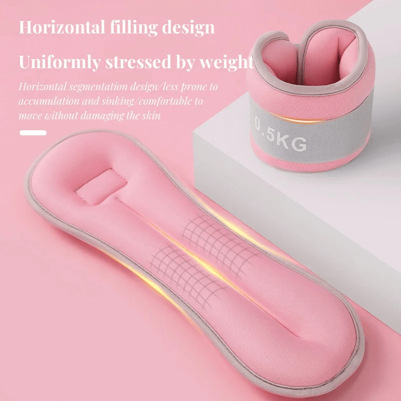 Pink adjustable wrist and ankle weights with 0.5kg label, featuring horizontal filling and soft elastic lining for comfort.