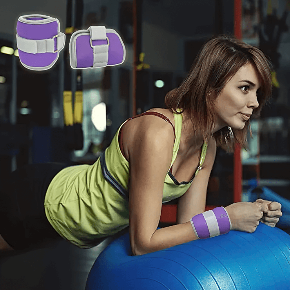 Woman using purple ankle and wrist weights with Velcro strap on exercise ball in gym