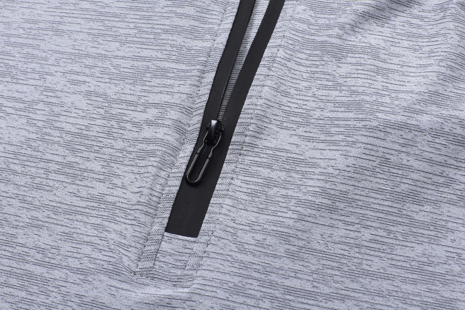 Close-up of a gray breathable athletic t-shirt with a stylish zip collar, highlighting the quick-dry fabric texture.