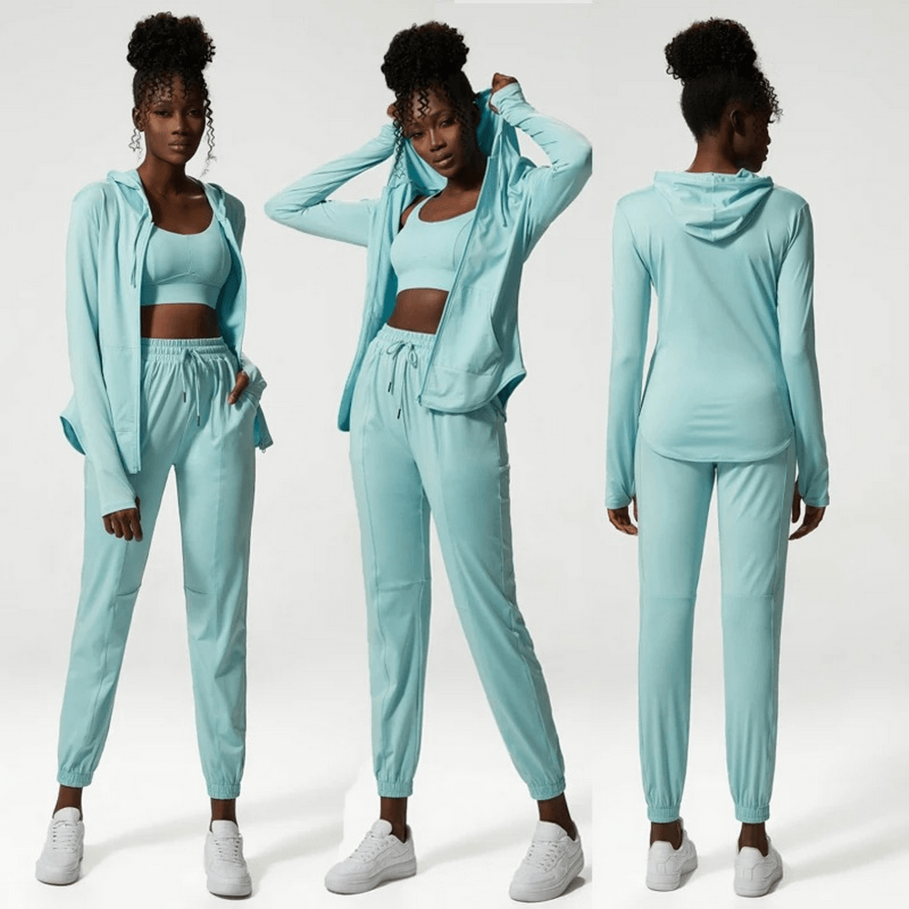 Woman modeling a stylish three-tone athletic clothing set featuring a jacket, top, and joggers in light teal, ideal for active lifestyles.