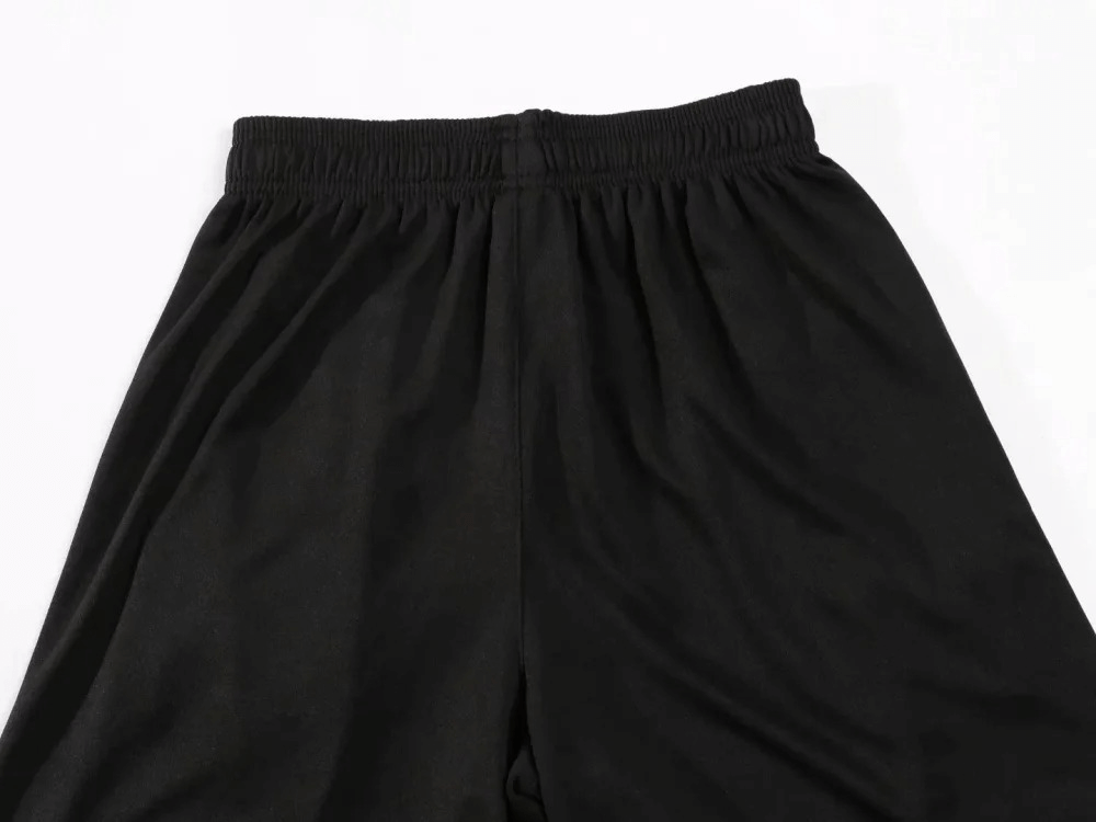 Close-up of black athletic shorts from the Athletic O-Neck Sportswear Set for men, highlighting elastic waistband and sleek polyester material.