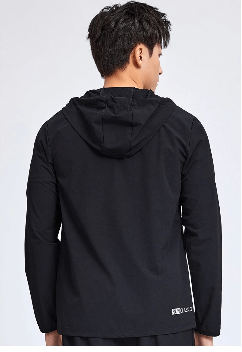 Man wearing black hooded athletic windbreaker, showcasing the back zip-up design and sporty style.