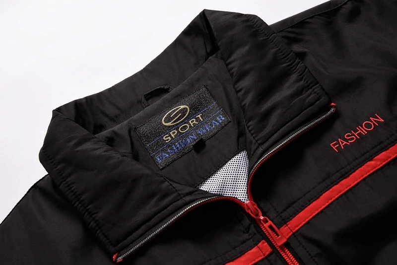 Close-up of a black and red athletic zip jacket collar with mandarin design, showcasing stylish outdoor sportswear details.