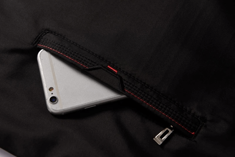 Close-up of tracksuit pocket with zipper detail, holding a smartphone. Stylish and functional design for outdoor sports fashion.
