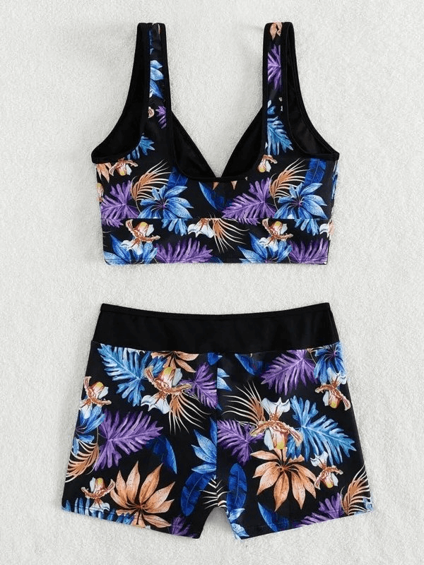 Floral print women's two-piece swimsuit on white background, featuring a vibrant tropical design. Perfect for swimming and beach outings.