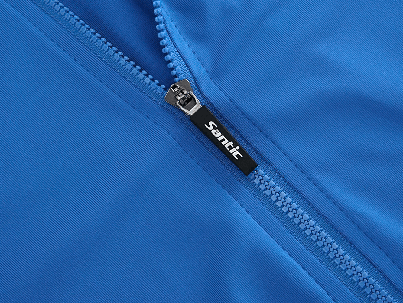 Close-up of blue bike apparel zipper with brand label, emphasizing durability and style for cyclists.