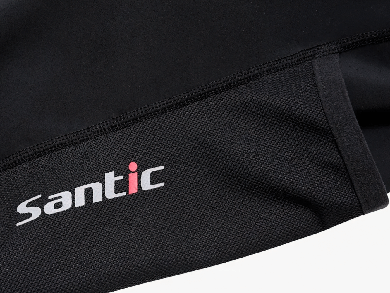 Close-up of Santic logo on black cycling apparel fabric.