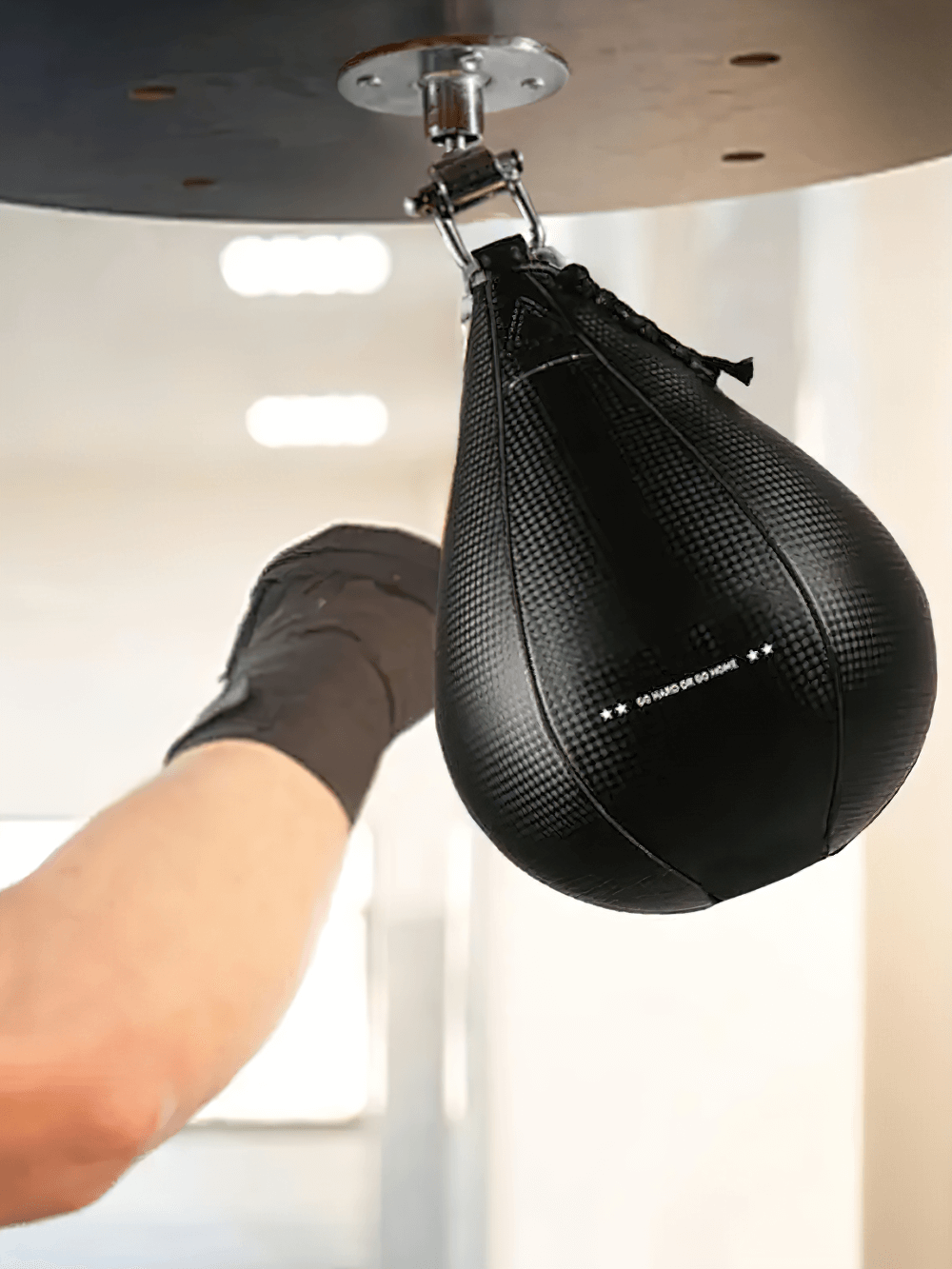 Boxer training with Black PU Speed Ball for precision and reflex drills, hanging from ceiling setup in gym.