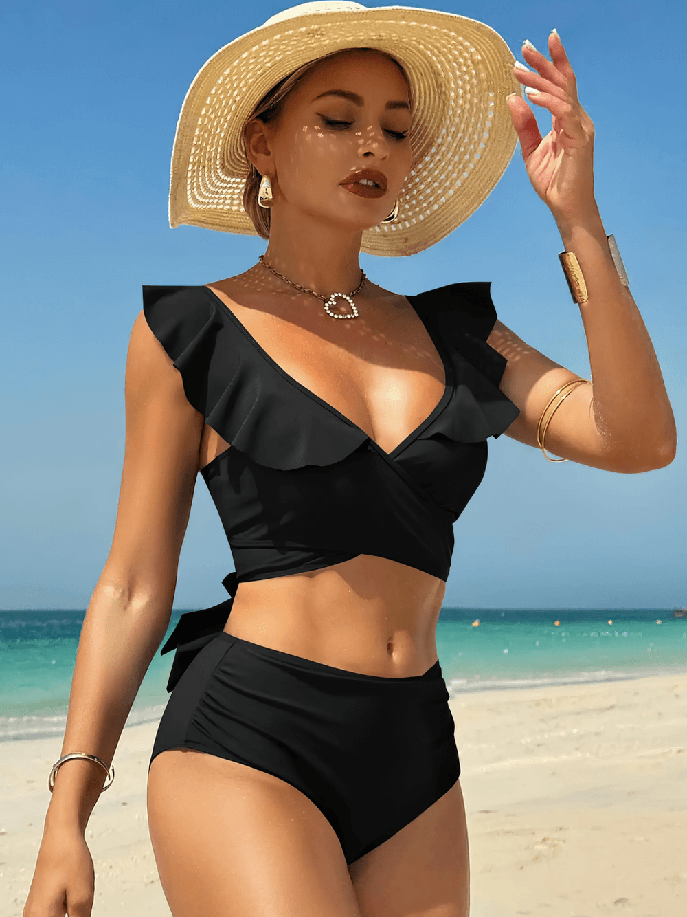 Black Ruffle Wrap High Waist Two Piece Swimsuit - SF4681 worn by model on the beach with sunhat and ocean in background.