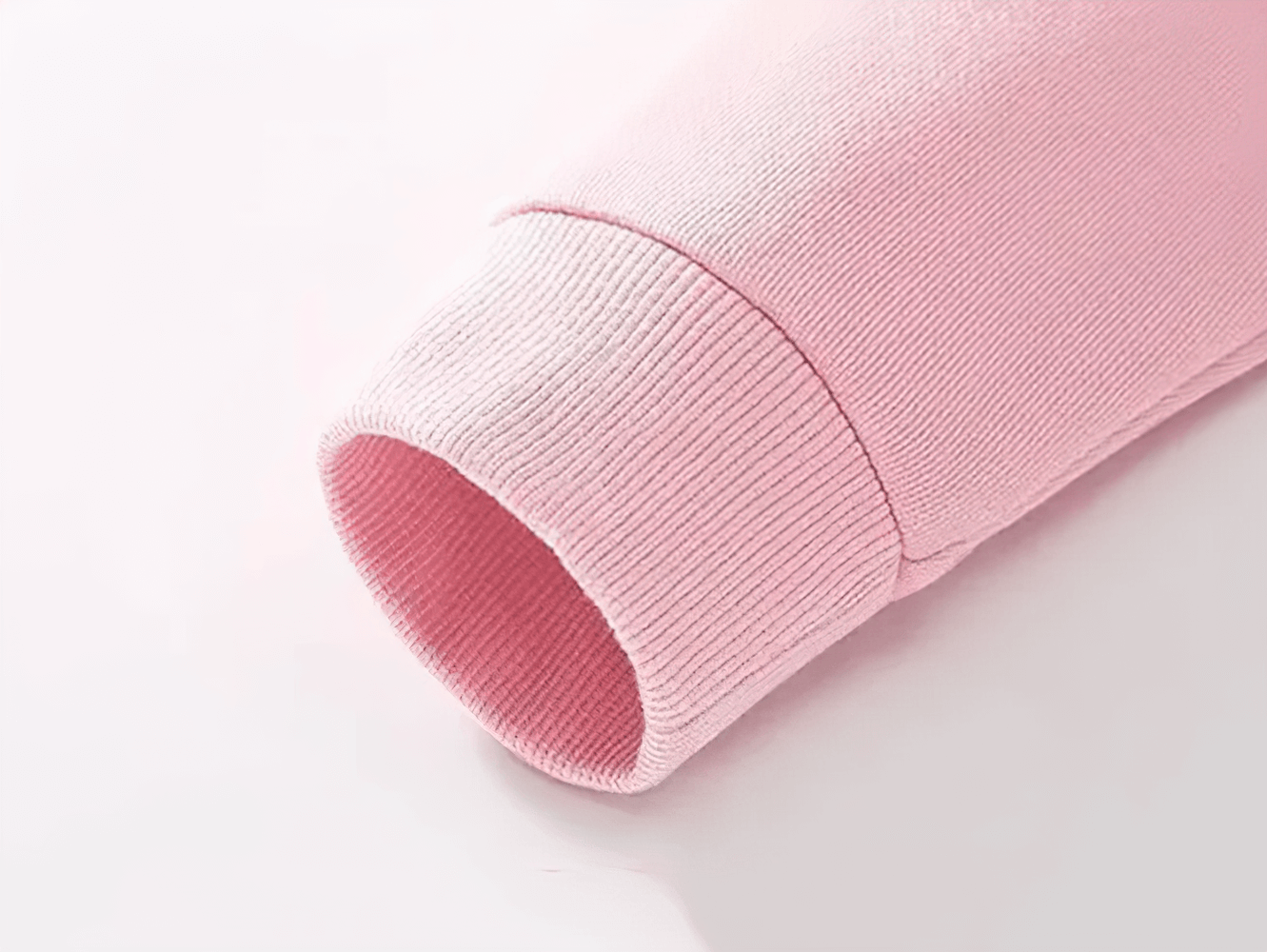Close-up of a pink sweatshirt sleeve with ribbed cuff, highlighting soft fabric texture for kids' fashion