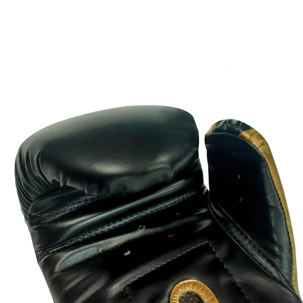 Close-up of black boxing glove with gold accents and Velcro closure for secure fit.