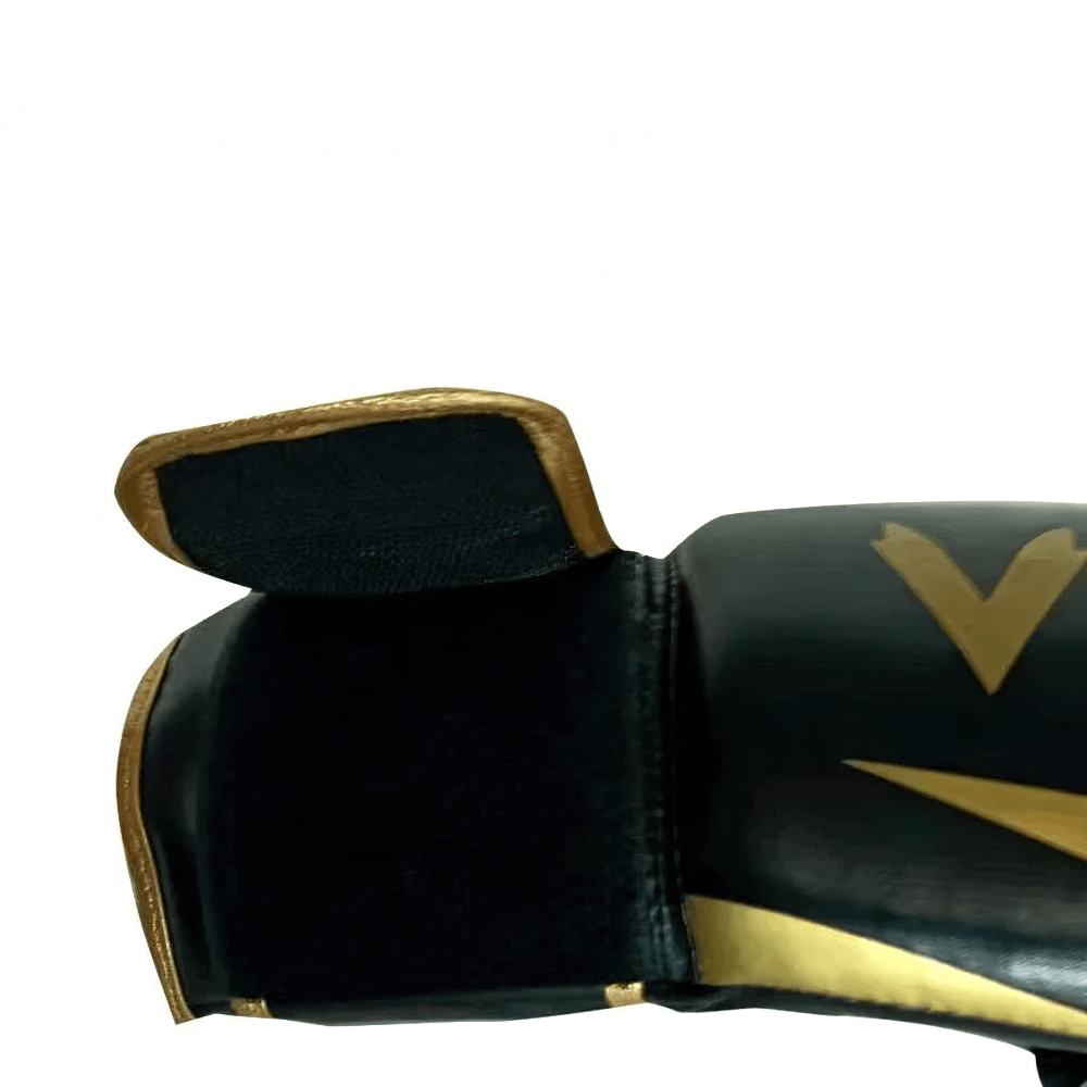 Muay Thai durable boxing glove with secure Velcro closure, black and gold design, breathable palm, unisex, ideal for fitness.