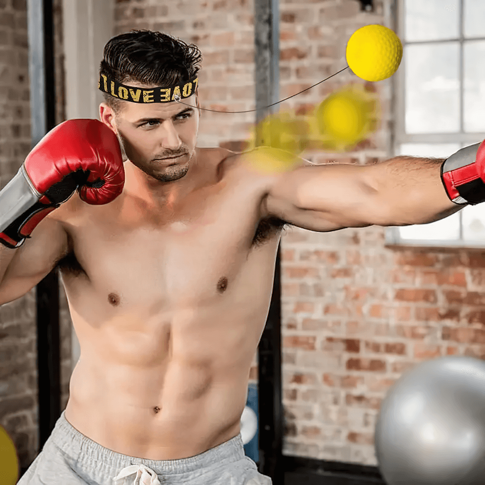 Man training with boxing reflex ball wearing a headband, focusing on agility and speed in an indoor setting.